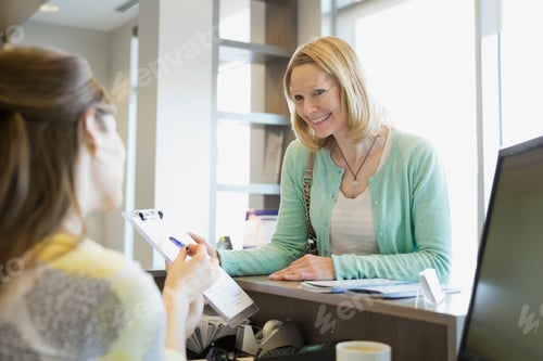 Preview: Receptionist Explaining Paperwork To Patient In Dentists Office