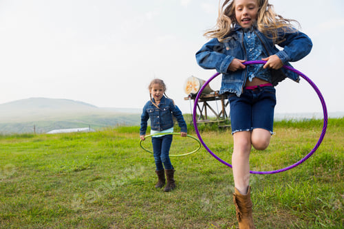 Preview: Girls Playing With Plastic Hoops In Rural Field