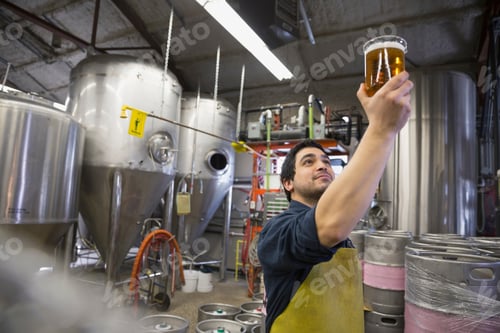 Preview: Brewery Worker Examining Beer In Beaker
