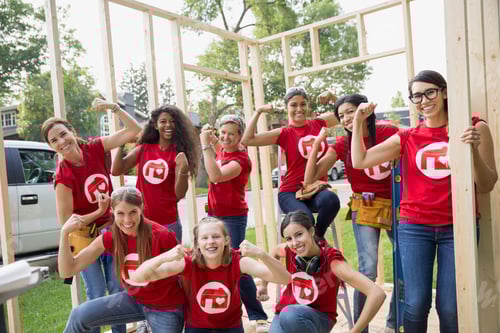 Preview: Female Volunteers Flexing Muscles At Construction Frame