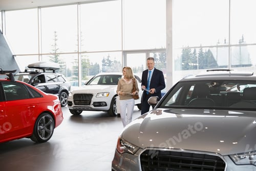 Preview: Couple Shopping In Car Dealership Showroom