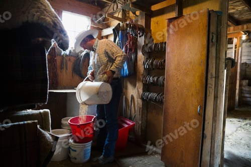 Preview: Rancher Filling Bucket With Grains In Barn