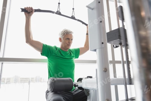 Preview: Man Using Weight Machine At Gym
