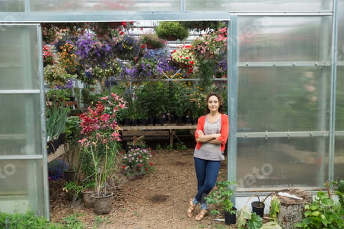Preview: Confident Woman In Doorway Of Plant Nursery Greenhouse