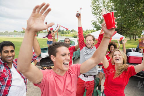 Preview: Friends Cheering At Tailgate Barbecue In Field