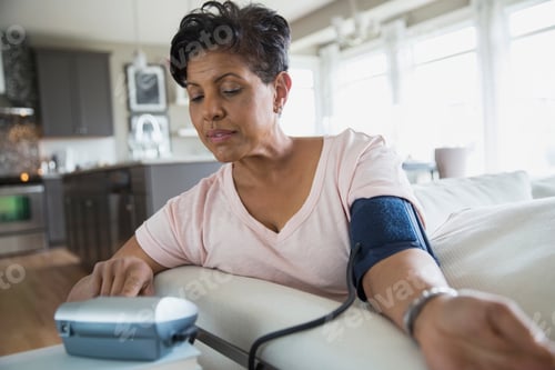 Preview: Woman Checking Blood Pressure In Living Room