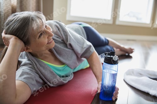 Preview: Smiling Woman Laying On Yoga Mat