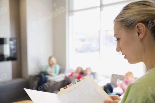 Preview: Dental Assistant Reviewing Medical Record In Lobby