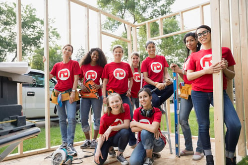 Preview: Portrait Of Smiling Female Volunteers At Construction Frame