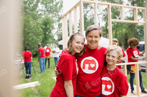 Preview: Portrait Of Smiling Volunteers At Construction Frame