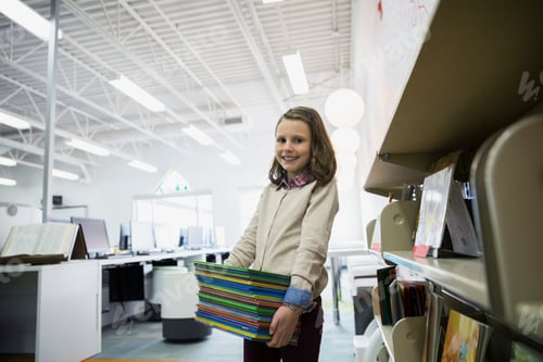 Preview: Portrait Of Elementary Student Carrying Stack Of Books