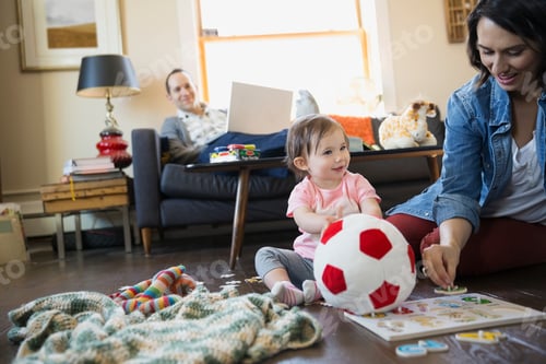 Preview: Young Family Playing And Relaxing In Living Room