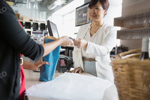 Preview: Cashier Taking Customer Credit Card In Wine Store