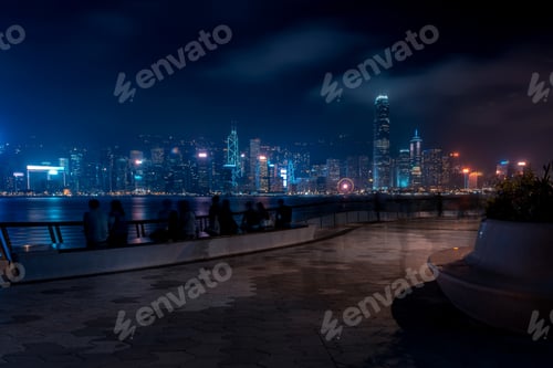 Preview: Hong Kong Cityscape At Night. Tourists Walking On The Waterfront