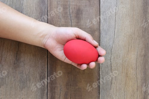 Preview: Easter Eggs In Hand On Wood Background,Handmade Painted For Design Happy Easter Day.