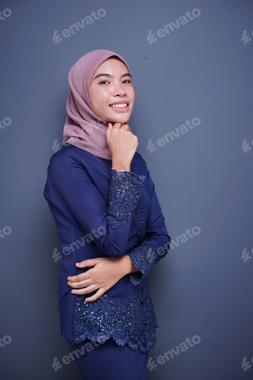 Visualização: Closeup de uma linda modelo muçulmana vestindo um Kurung moderno azul escuro com hijab, um moderno