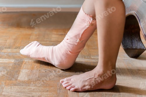 Preview: Injury Women Foot With Splint On The Leg Sitting On Couch At Home.
