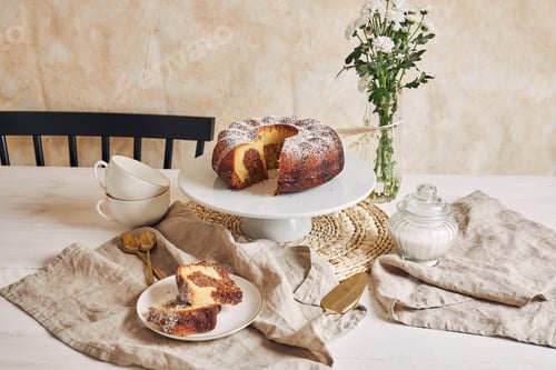 Preview: A Beautiful Shot Of A Delicious Ring Cake Put On A White Plate And A White Flower Near It