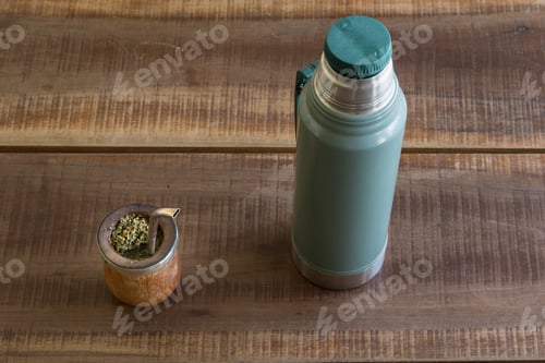 Preview: A Top View Of Mate Caffeine-Rich Infused Drink In A Palo Santo Wood Cup Next To A Thermos Bottle