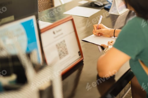 Preview: Businesswoman Hand Signing Hotel Agreement Contract At Reception Desk.