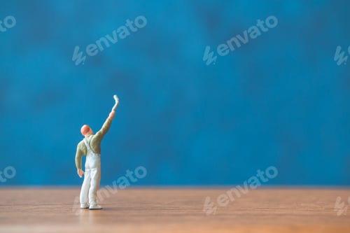 Preview: Miniature People Holding Brush In Front Of A Blue Wall Background