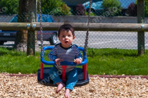 Preview: A Closeup Shot Of A Cute Toddler Sitting In A Swing