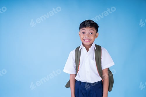 Visualização: Um estudante asiático em êxtase vestindo camisa branca, calça azul e mochila sobre fundo azul