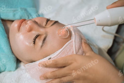 Preview: Young Woman Relax Having Facial Treatment Using A Facial Massage Machine
