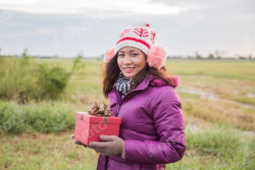 Preview: Happy Young Woman With Gift In Hands. Christmas And Winter Concept.