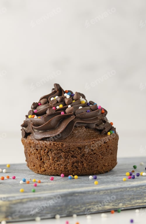 Preview: A Vertical Shot Of A Deliciously Baked Sprinkled Chocolate Cupcake