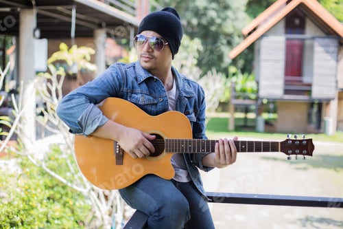 Preview: Young Hipster Man Playing Guitar To Relaxing On His Holiday, Enjoy With Natural And Fresh Air.