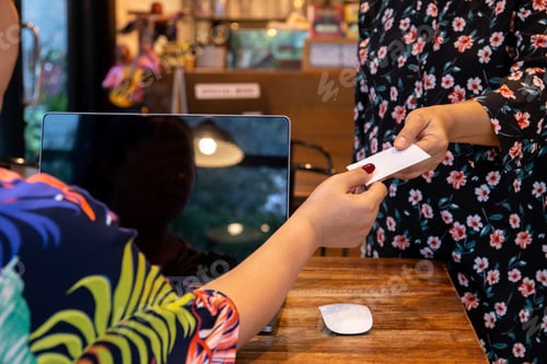 Preview: Businesswoman Handing Out A Business Card To Customer In Cafe.