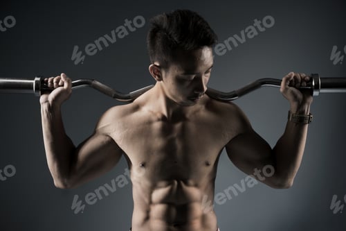 Preview: Closeup Of An Attractive Muscular Bodybuilder With A Barbell On Dark Background