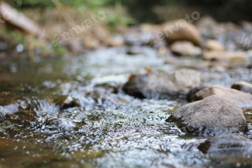 Preview: A Closeup Of A River Flowing In A Park Under The Sunlight With A Blurred Background