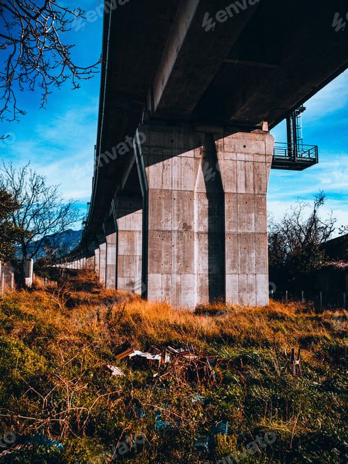 Preview: A Vertical Shot Of A Stone Bridge And A Field Of Green And Yellow Grass Under It