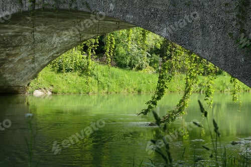 Preview: A Beautiful View Of A Concrete Arch Bridge Over A Lake Surrounded By Greenery