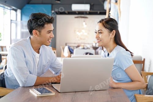 Preview: Smiling Young Adults Working Together in Cafe
