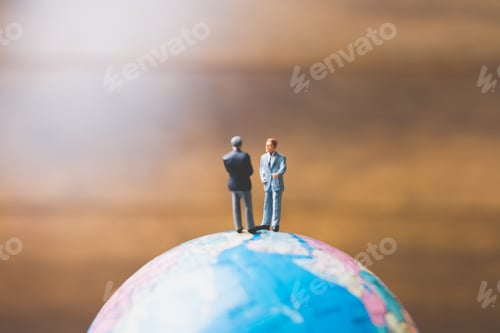 Preview: Miniature People , Businessman Standing On The Globe World Map With Brown Background And Copy Space