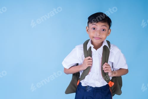 Preview: A Smiling Asian School Boy Wearing White Shirt, Blue Pants And Backpack Over Blue Background