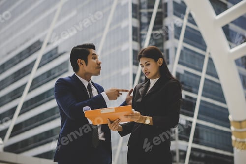 Preview: Business Colleague Talking And Viewing Documents Outdoor