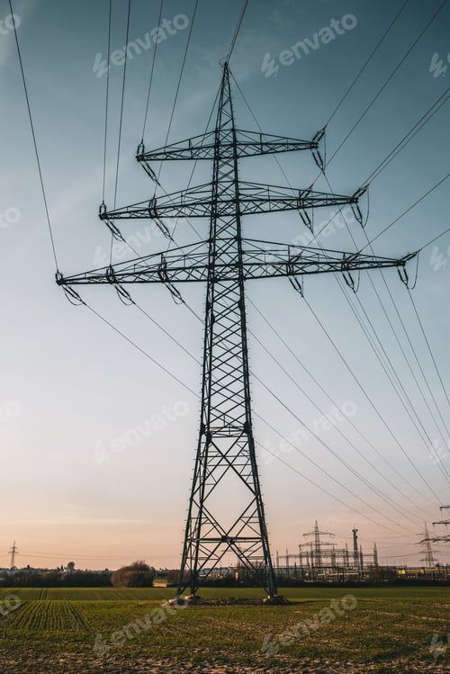 Preview: A Vertical Shot Of An Electric Pole Under A Blue Cloudy Sky