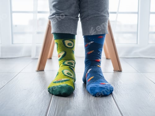 Preview: A Closeup Of Two Different Artistic Socks On Feet, With Avocados On The Left And Blue Space On The