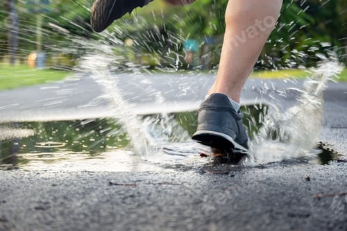 Preview: Man Exercise Running Through Puddle Splashing His Shoes.