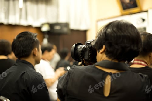 Preview: Woman Taking Picture Of Her Colleagues In Conference Room