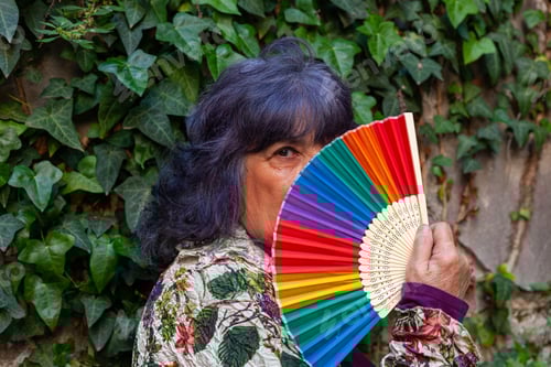 Preview: A Hispanic Senior Female Posing With A Hand Fan With The Lgbt Flag Colors