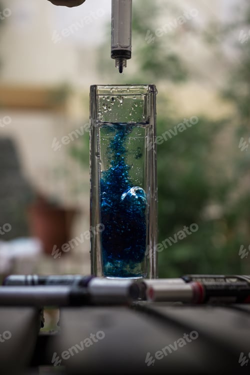 Preview: A Blue Coloring Added Into A Colorless Drink In A Glass