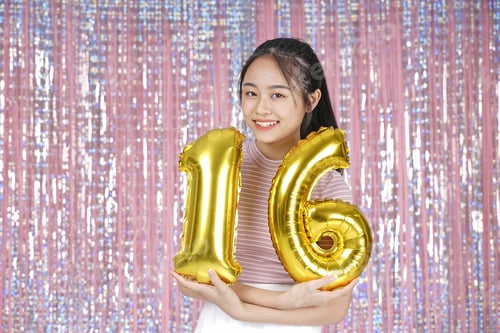Preview: Asian Young Teenager Pretty Cheerful Beautiful Girl With Party Gold Foil Balloon, On Pink Sparkling