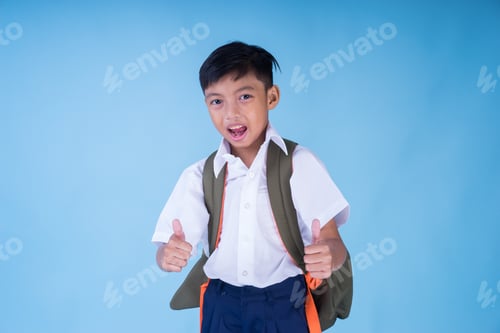 Preview: An Ecstatic Asian School Boy Wearing White Shirt, Blue Pants And Backpack Over Blue Background