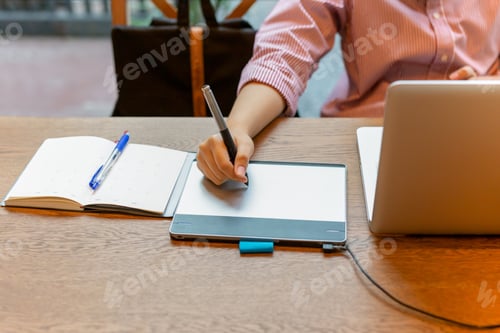 Preview: Graphic Designer Using Digital Tablet With Laptop On The Desk