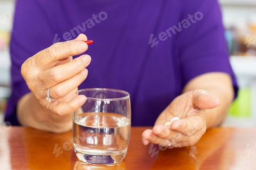 Preview: Senior Woman Hands Holding Tablet With Glass Of Water On Table.